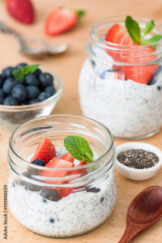 Chia seed pudding with fresh strawberries and blueberries on wooden table. Selective focus. Concept of dieting, clean eating, healthy lifestyle and weight loss food