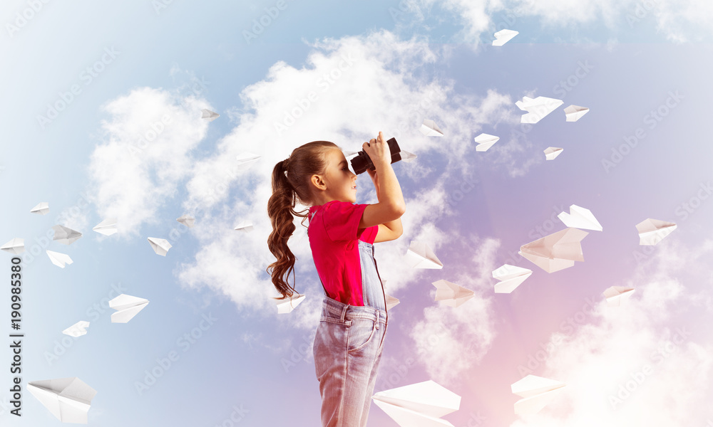 Concept of careless happy childhood with girl looking in binoculars