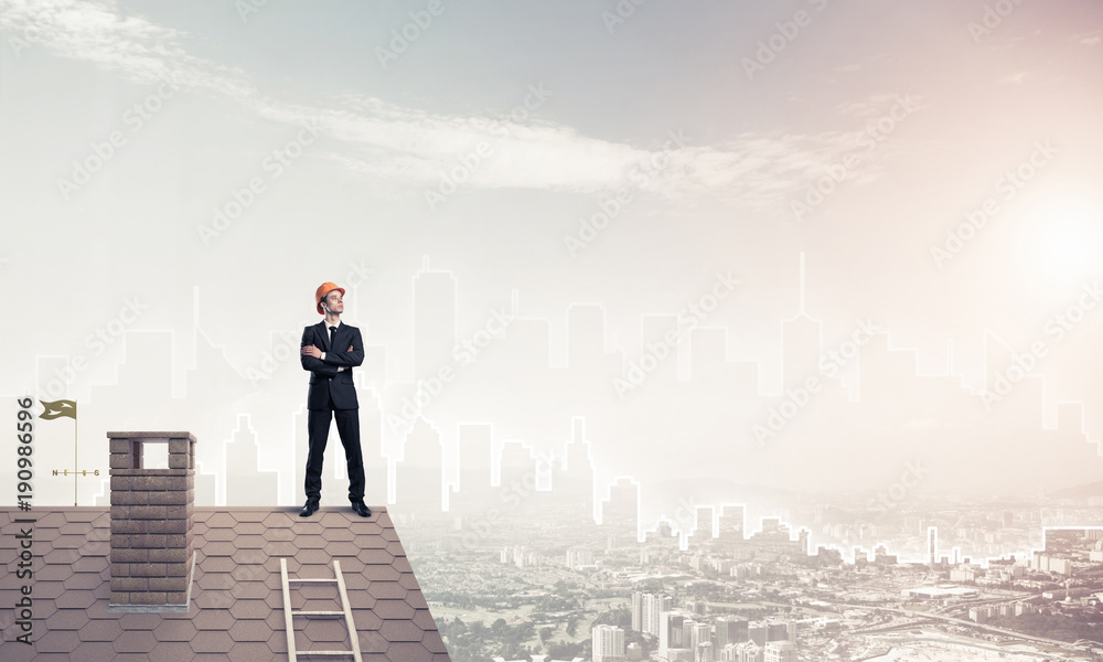 Engineer man standing on roof and looking away. Mixed media Engineer man standing on roof and looking away. Mixed media