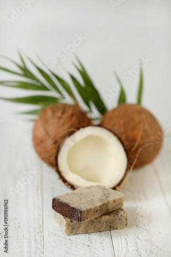 soap with coconut extract. Handmade soap with coconut oil and fresh cut coconut in a cut on a white shabby wooden background. Handmade fruit soap. Organic Cosmetics for Beauty