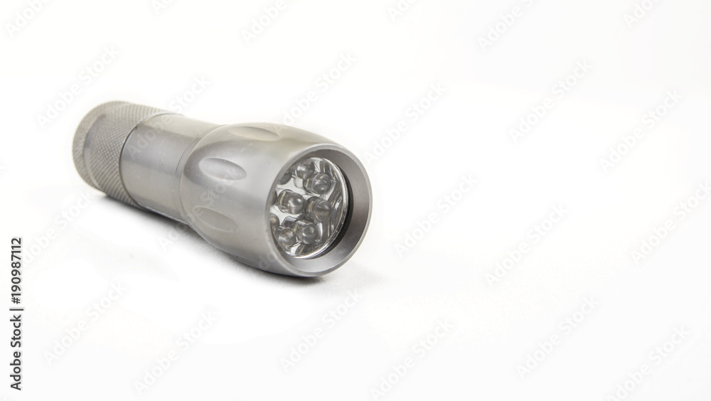 Small home pocket led flashlight in hand on the white Small home pocket led flashlight in hand on the white