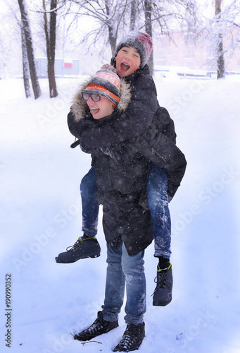 two teenager bpy having winter fun playing on snowfall park photo