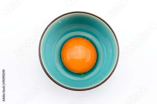 Egg yolk in bowl on white background © Yanawut Suntornkij