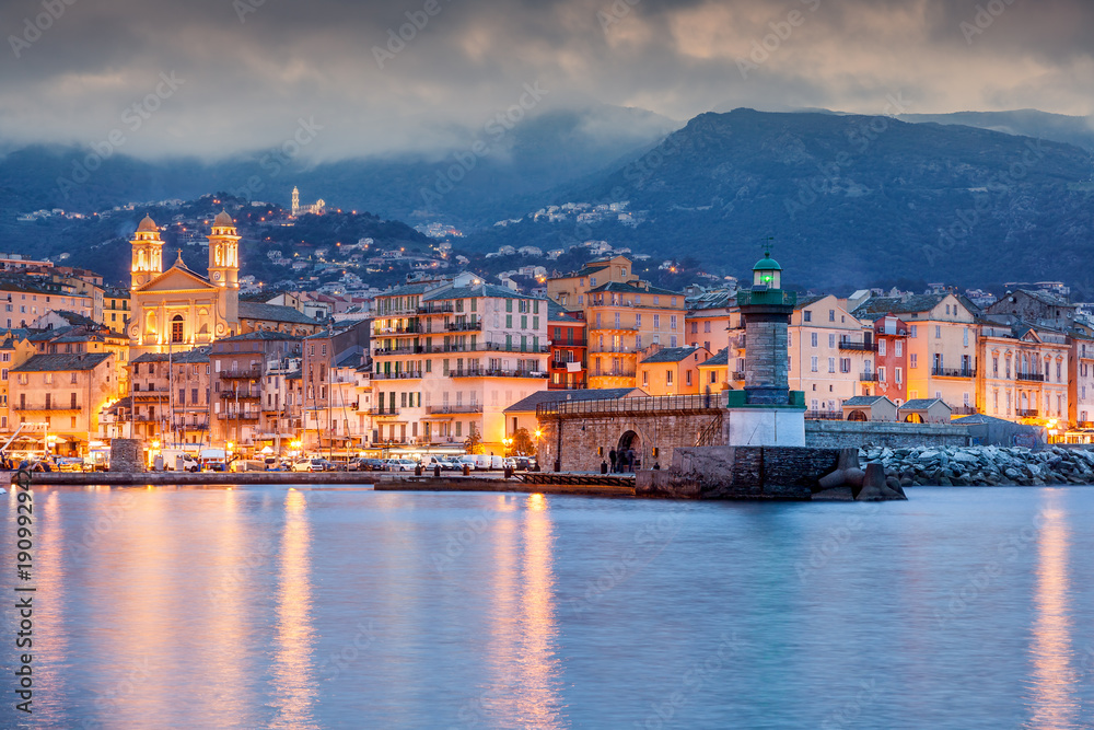 Bastia, a beautiful city landscape, a port with boats, a sunset and the lights of a night city. France, Corsica, a popular destination for travel in Europe