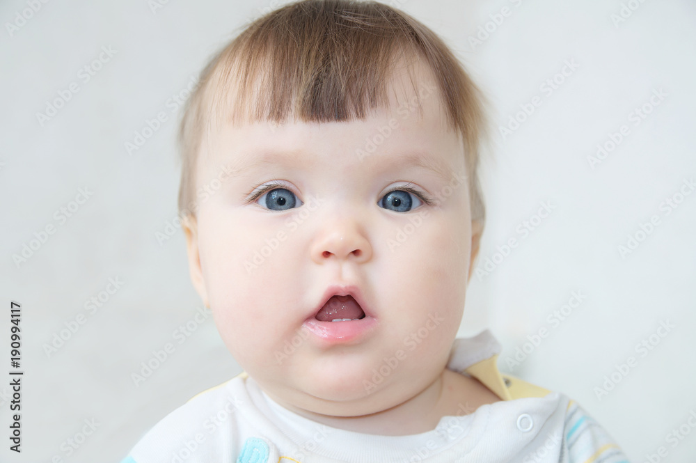 baby portrait with open mouth looking with interest, happy Caucasian infant nine month kid face,European little girl looking at camera