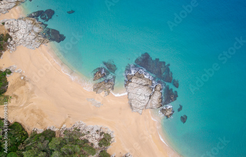 Aerial views of the rocks in the sea on a sunny day.