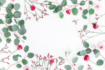 Flowers composition. Frame made of eucalyptus branches and pink flowers on white background. Flat lay, top view, copy space