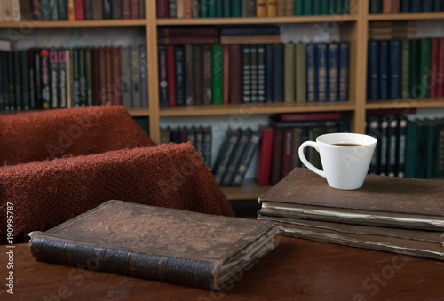 Sweet moments of relaxation with books and a cup of coffee. Vintage books, glasses, chair, library