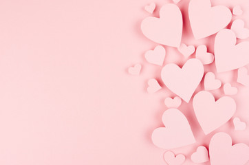 Paper pink hearts fly on soft pink color background, border, copy space. Valentine day concept for design.