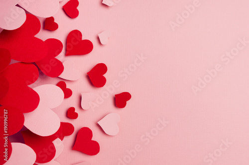 Paper red and pink hearts soar on soft pink color background. Valentine day concept for design, copy space.
