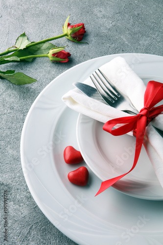 Festive table setting for Valentine's Day with fork, knife and rose