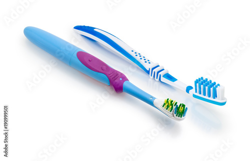 Electric and conventional toothbrushes on a white matte surface