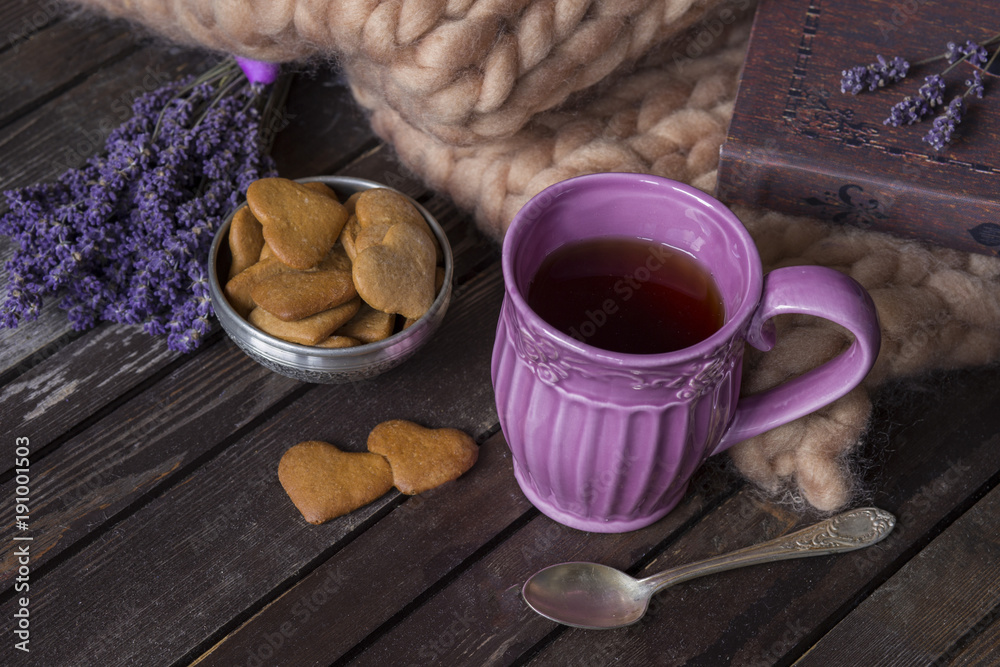on a wooden table lavender, plaid, book, purple tea mug, and cookies