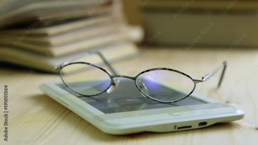 E-book, glasses and a paper book. Education and information. E-book, glasses and a paper book. Education and information.