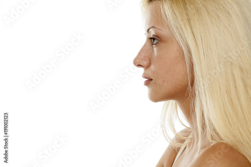 Profile of young blonde woman without makeup on white background