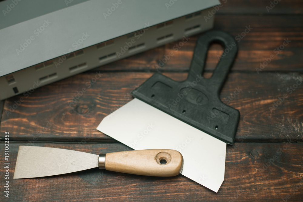 Set of construction and repair tools, small house on wooden board background, top view, closeup Set of construction and repair tools, small house on wooden board background, top view, closeup
