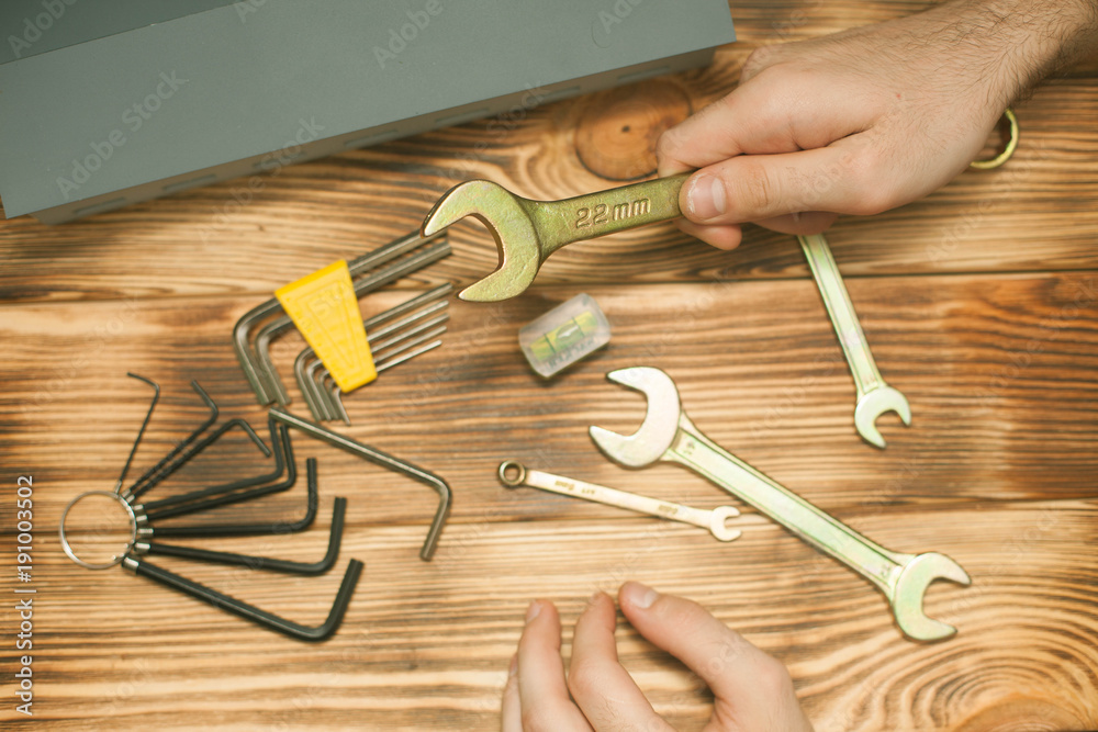 Set of construction and repair tools, small house on wooden board background, top view, closeup