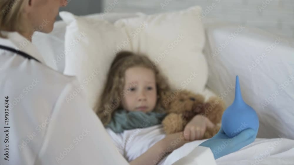 Therapist showing squeeze bulb to scared sick child, problems with digestion Therapist showing squeeze bulb to scared sick child, problems with digestion