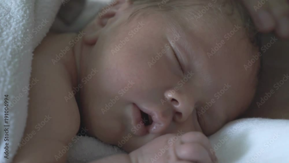 Newborn baby having a nap and his mother touches him
Newborn baby having a nap and his mother touches him