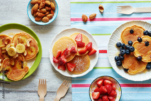 Wallpaper Mural Homemade pancakes with strawberry, banana, blueberry, cashew, almond and honey on white table. Family breakfast for 3 person. Torontodigital.ca