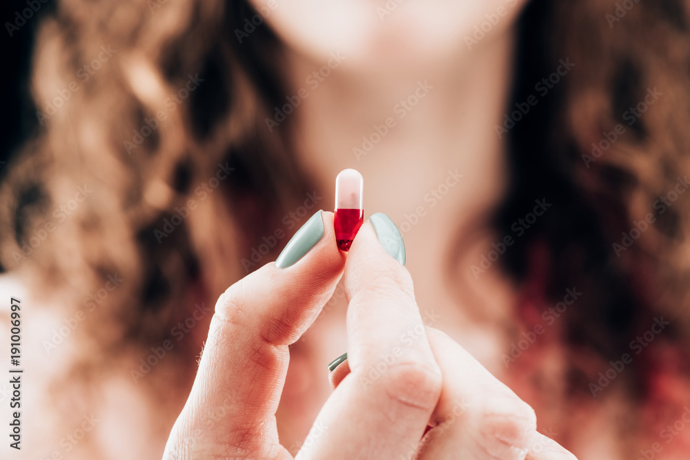 partial view of woman showing pill in hand partial view of woman showing pill in hand