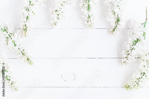 Flowers composition. Frame made of white lilac flowers on white wooden background. Flat lay, top view, copy space