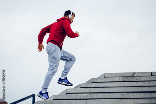 Handsome man running up at stairs