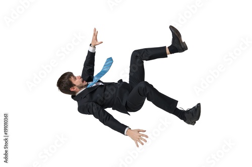 Young businessman falling down in free fall. Isolated on white background. photo