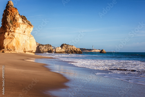 Beautiful ocean landscape, the coast of the Atlantic Ocean, Portugal, the Algarve. Blue ocean, cloudless sky, yellow rocks