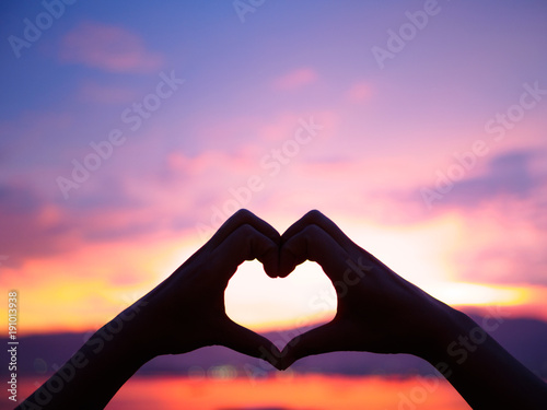 Silhouette the woman hands to be heart shape on sunset background. Happy  Love  Valentine s day idea  sign  symbol  concept.