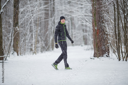 Photo of man in sports clothes on run in winter
