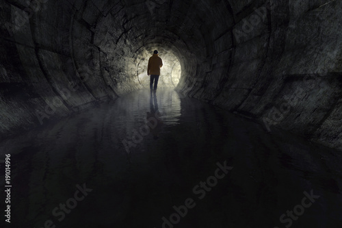 Mann mit Taschenlampe in Abwasserkanal