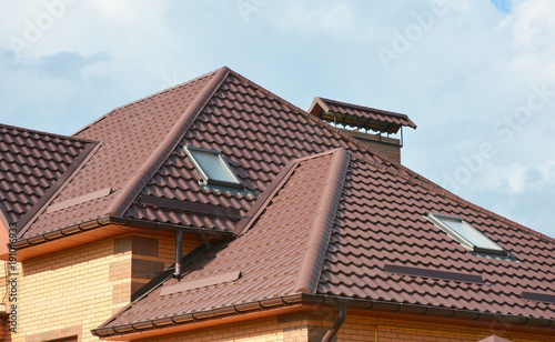 Metal roof with modern house attic construction with roof gutter