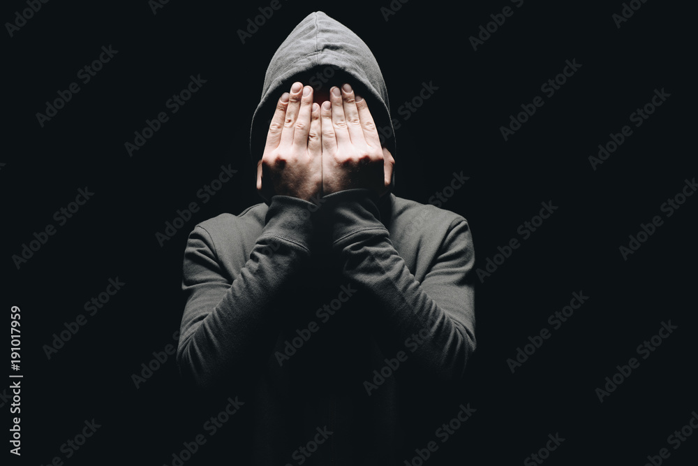 Φωτογραφία cropped shot of man in hoodie closing eyes with hands isolated on black