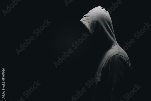 side view of unrecognizable man in man standing isolated on black