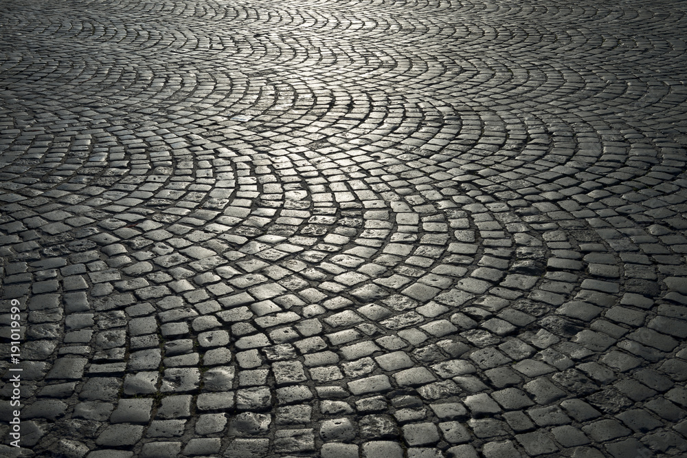 Full frame background of old-fashioned European cobbled plaza laid out in circular pattern in Naples, Italy