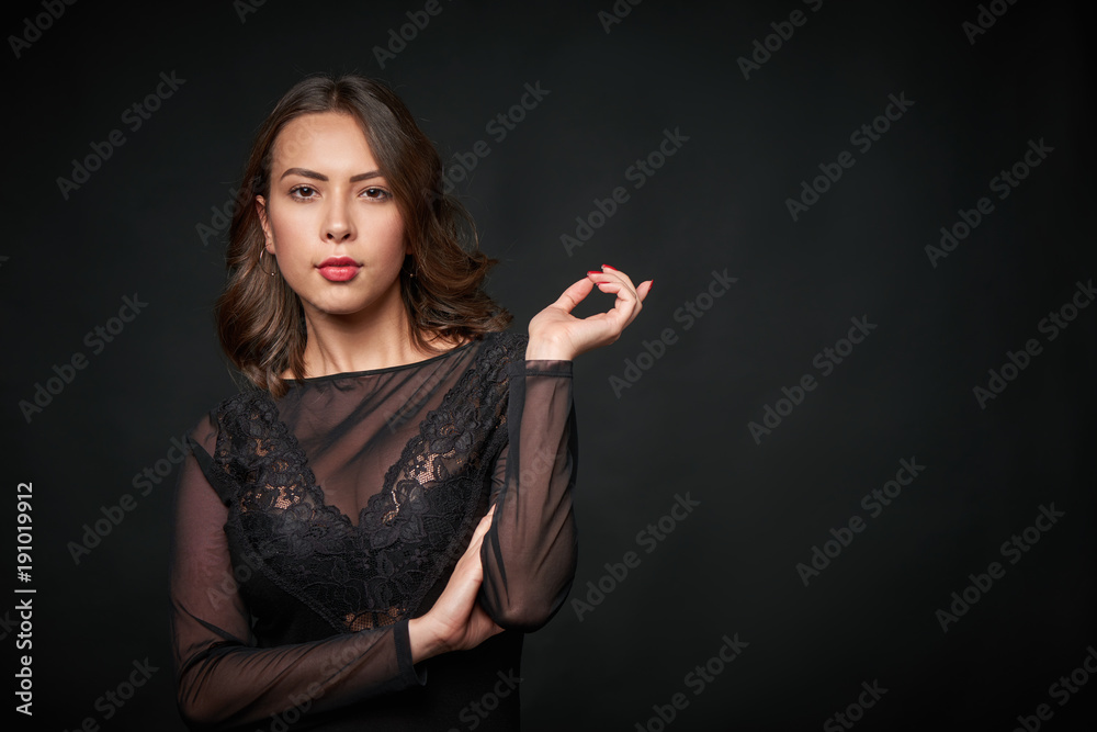 Φωτογραφία Portrait of sensual beautiful woman in black lace clothing pointing finger at bl