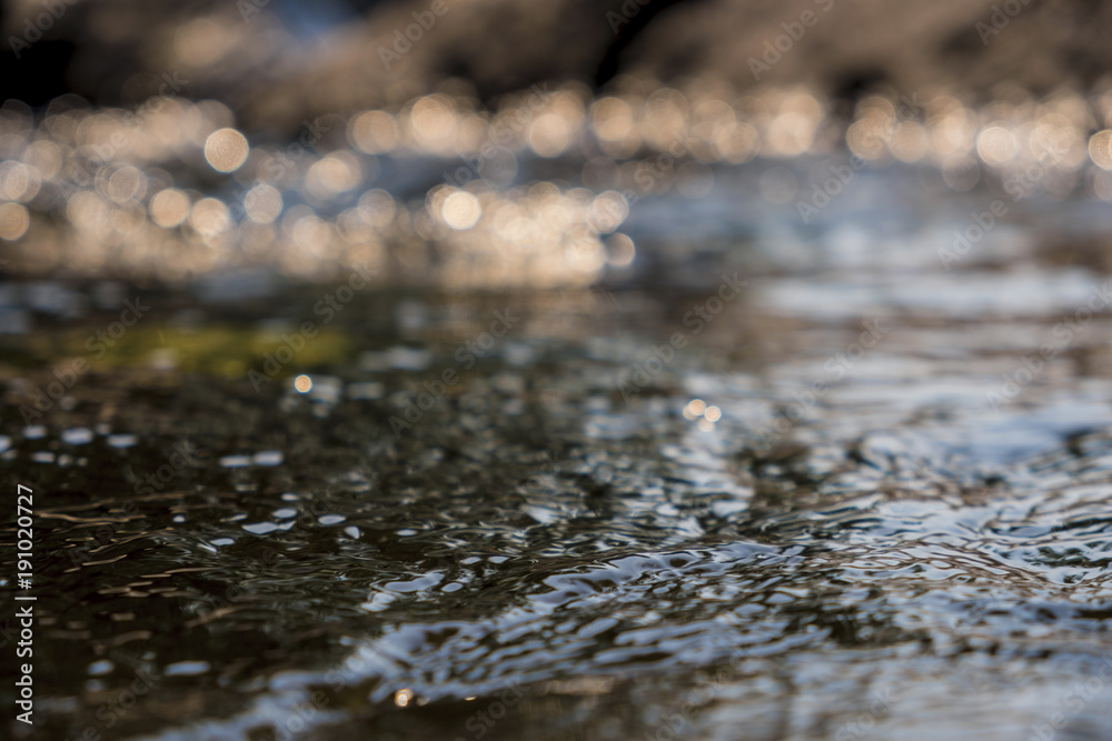 Fototapeta premium Close up.Flowing water with a bokeh sunlight background.