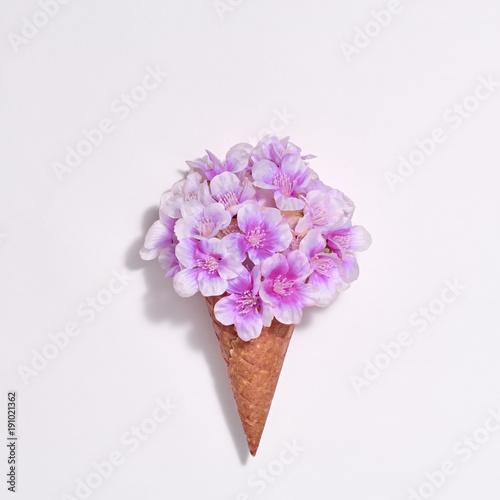 Ice Cream Cone with Bouquet of Flowers. Spring Summer Floral concept. Creative Minimal. Purple Blossom, Vanilla Color. Trendy fashion Style. Art