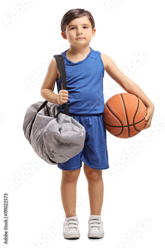 Little basketball player holding a sports bag and a basketball