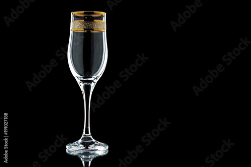 glass of wine with a gold rim  on a black background (isolate).