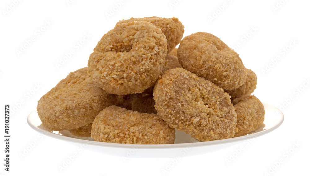 Side view of several small bite size caramel flake donuts on a plate isolated on a white background. Side view of several small bite size caramel flake donuts on a plate isolated on a white background.