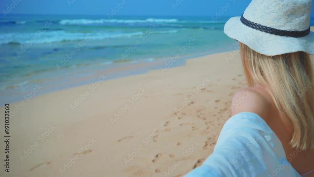 Woman walking on the ocean beach under blue sky in sunny day. Seascape view with palms. Woman walking on the ocean beach under blue sky in sunny day. Seascape view with palms.