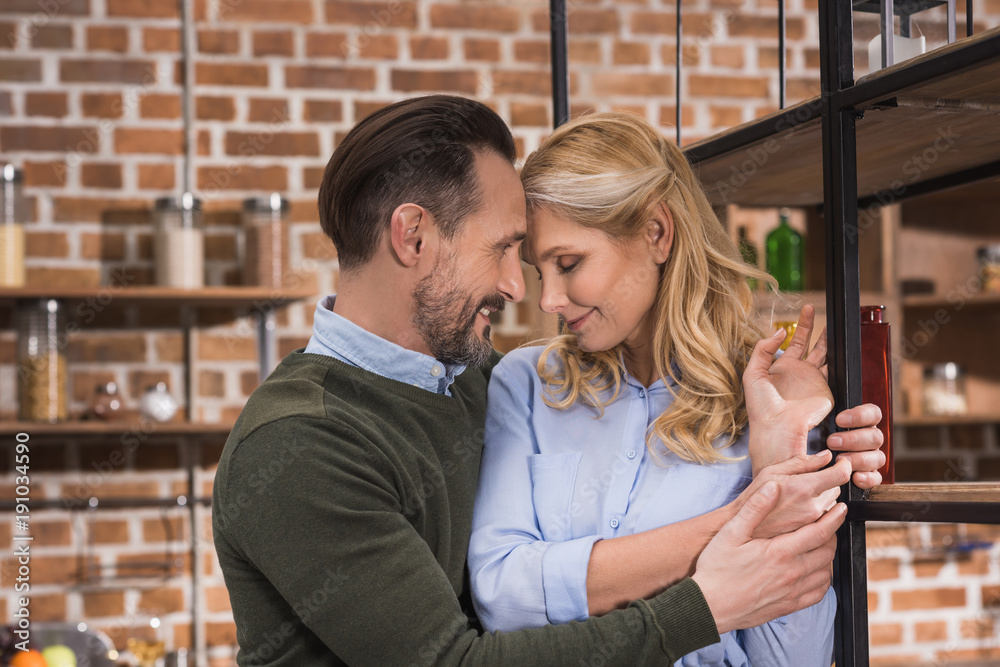 happy husband hugging wife at kitchen happy husband hugging wife at kitchen