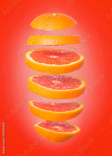 Creative concept with flying orange. Sliced orange isolated on white background. Levity fruit floating in the air.