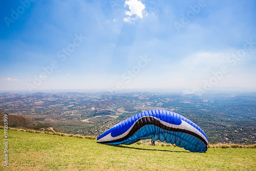 Belo Horizonte, Minas Gerais, Brazil. Paraglider starting a flight from top of the world mountain photo