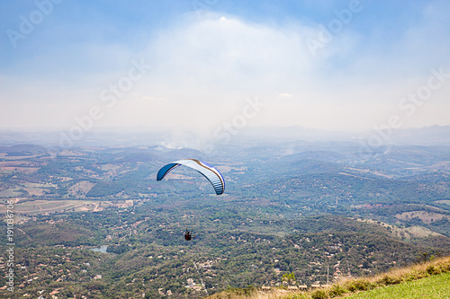 Belo Horizonte, Minas Gerais, Brazil. Paraglider flying from top of the world mountain photo