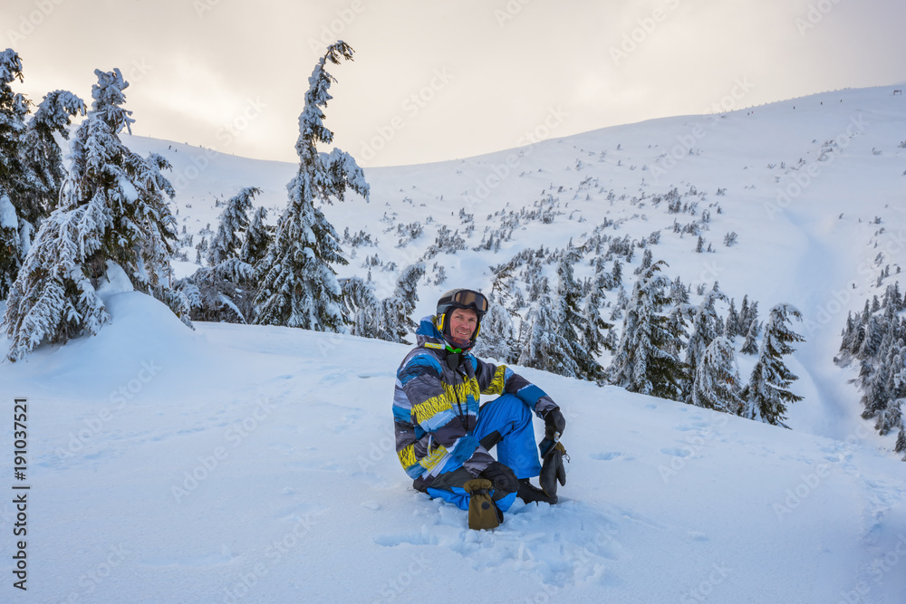 Snowboarder resting during a freeride