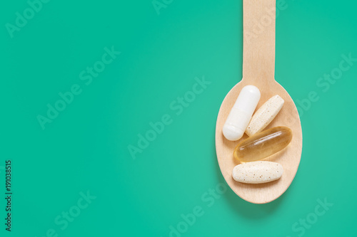 Fototapeta Naklejka Na Ścianę i Meble -  Wooden spoon with daily dose healthy supplements