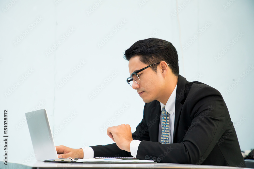 Business man working at office with laptop and documents on his desk Business man working at office with laptop and documents on his desk